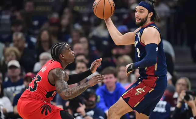 Cleveland Cavaliers guard Max Strus looks to pass whil being guarded by Toronto Raptors guard Jamal Shead during the first half in Game 1 of a first-round NBA playoffs basketball series, Saturday, April 18, 2026, In Cleveland. (AP Photo/David Dermer)
