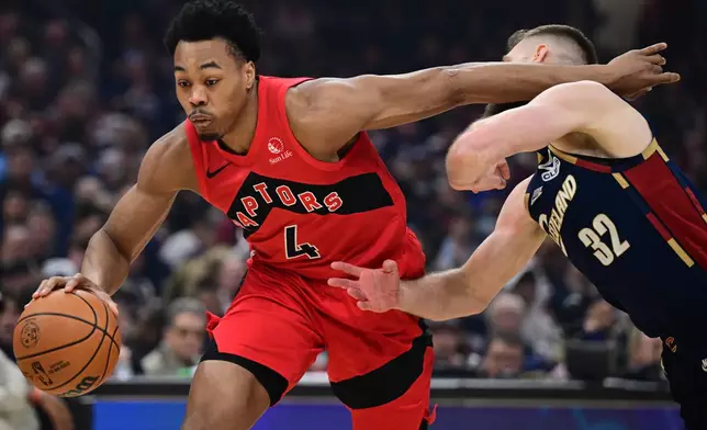Toronto Raptors forward Scottie Barnes drives on Cleveland Cavaliers forward Dean Wade during the first half in Game 1 of a first-round NBA playoffs basketball series, Saturday, April 18, 2026, In Cleveland. (AP Photo/David Dermer)
