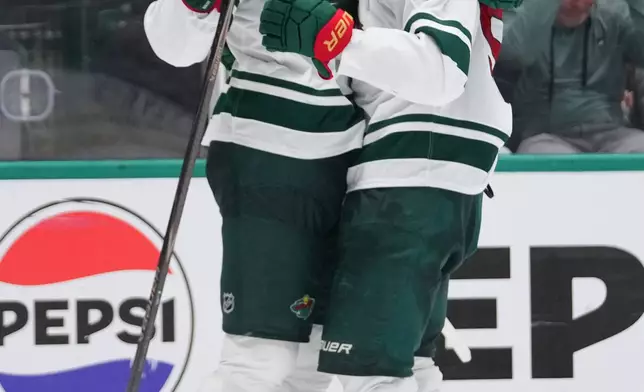 Minnesota Wild left wing Matt Boldy, left, celebrates his second period power play goal with left wing Kirill Kaprizov in Game 5 of a first-round NHL Stanley Cup playoffs hockey series against the Dallas Stars, Tuesday, April 28, 2026, in Dallas. (AP Photo/Julio Cortez)