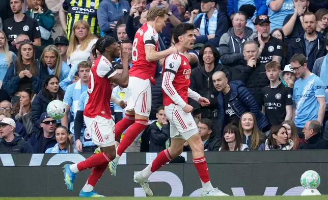 Arsenal's Kai Havertz celebrates with his teammates after scoring his side's first goal during the English Premier League soccer match between Manchester City and and Arsenal, in Manchester, England, Sunday, April 19, 2026. (AP Photo/Dave Thompson)