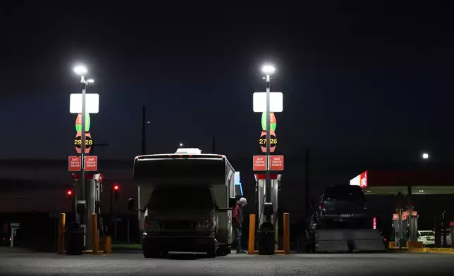 A man fiills up a recreational vehicle at a gas station on Tuesday, April 7, 2026, in Aurora, Ore. (AP Photo/Jenny Kane)