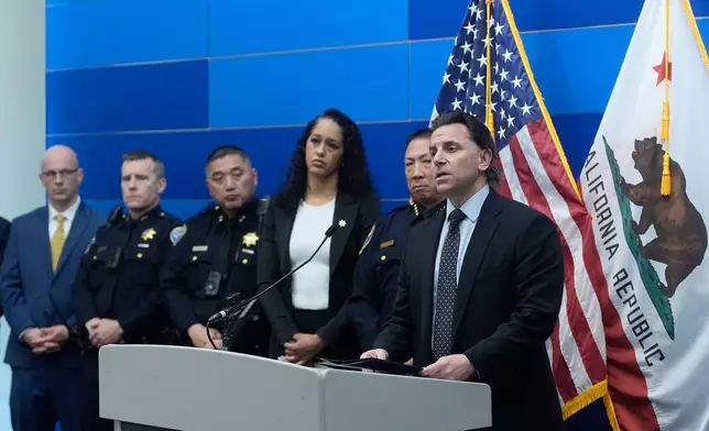 Matt Cobo, F.B.I. San Francisco Acting Special Agent in Charge, right, speaks next to San Francisco Police Chief Derrick Lew, second from right, and San Francisco District Attorney Brooke Jenkins, third from right, during a news conference Monday, April 13, 2026, in San Francisco. (AP Photo/Jeff Chiu)