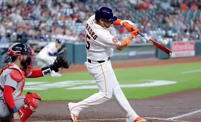 Houston Astros' Isaac Paredes, right, connects for an RBI double in front of Boston Red Sox catcher Connor Wong, left, during the first inning of a baseball game Wednesday, April 1, 2026, in Houston. (AP Photo/Michael Wyke)