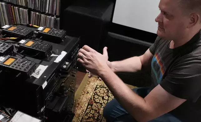 * Brian Emerick plays a recorded tape at his home in Des Plaines, Ill., Thursday, March 19, 2026. (AP Photo/Nam Y. Huh)