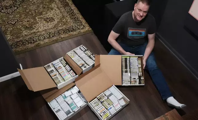 Brian Emerick poses with his recorded tapes for a photo at his home in Des Plaines, Ill., Thursday, March 19, 2026. (AP Photo/Nam Y. Huh)