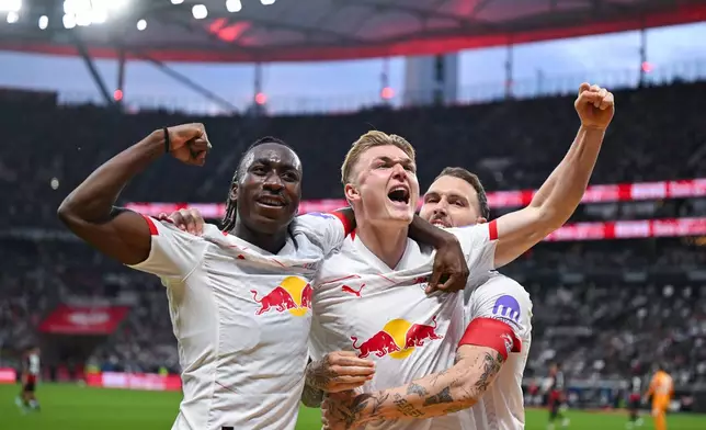 Leipzig's Conrad Harder, center, Yan Diomande, left, and David Raum celebrate their side's third goal of the game during the German Bundesliga soccer game between Eintracht Frankfurt and RB Leipzig in Frankfurt, Germany, Saturday, April 18, 2026. (Florian Wiegand/dpa via AP)