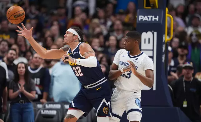 Denver Nuggets forward Aaron Gordon, left, pulls in a loose ball as Memphis Grizzlies guard Cedric Coward defends in the first half of an NBA basketball game Wednesday, April 8, 2026, in Denver. (AP Photo/David Zalubowski)