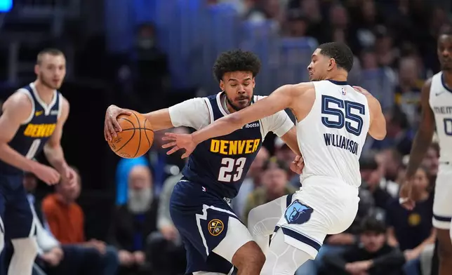 Denver Nuggets forward Cameron Johnson, left, drives to the rim as Memphis Grizzlies guard Lucas Williamson in the first half of an NBA basketball game Wednesday, April 8, 2026, in Denver. (AP Photo/David Zalubowski)