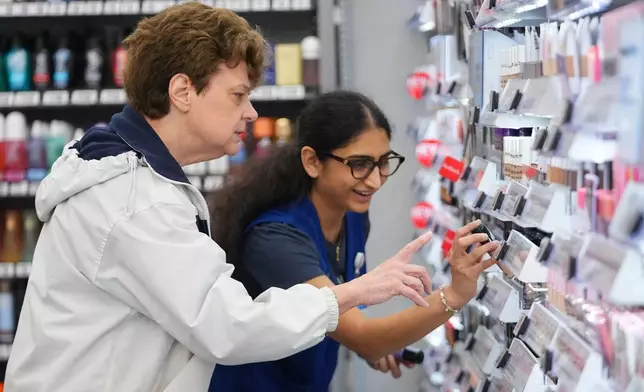 Priyanka Patil, right, fashion team lead at Walmart, helps Linda Flippin, of Colleyville, Texas, find a makeup item on the shelves near the store's beauty counter, Wednesday, April 29, 2026, in Grapevine, Texas. (AP Photo/Julio Cortez)