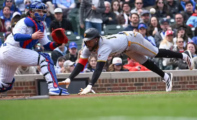 Pittsburgh Pirates' Oneil Cruz (15) scores past Chicago Cubs catcher Miguel Amaya (9) during the third inning of a baseball game, Saturday, April 11, 2026, in Chicago. (AP Photo/Matt Marton)
