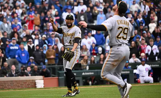 Pittsburgh Pirates pitcher Yohan Ramírez (49) points to a fly ball hit by Chicago Cubs' pinch hitter Seiya Suzuki that first baseman Ryan O'Hearn (29) then caught to end a baseball game, Saturday, April 11, 2026, in Chicago. (AP Photo/Matt Marton)