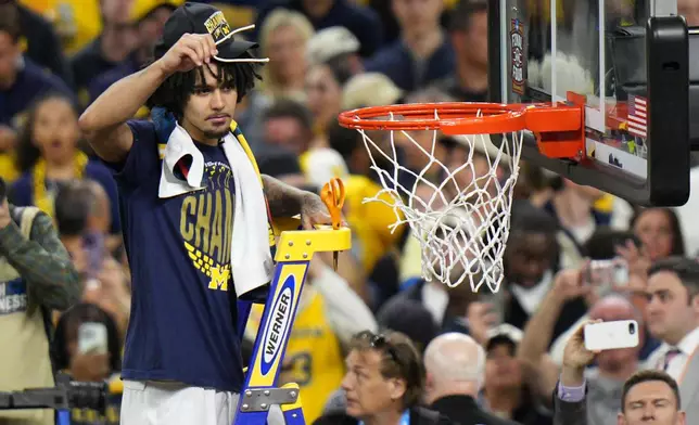 Michigan's Elliot Cadeau celebrates after defeating UConn in the NCAA college basketball tournament national championship game at the Final Four, Monday, April 6, 2026, in Indianapolis. (AP Photo/AJ Mast)