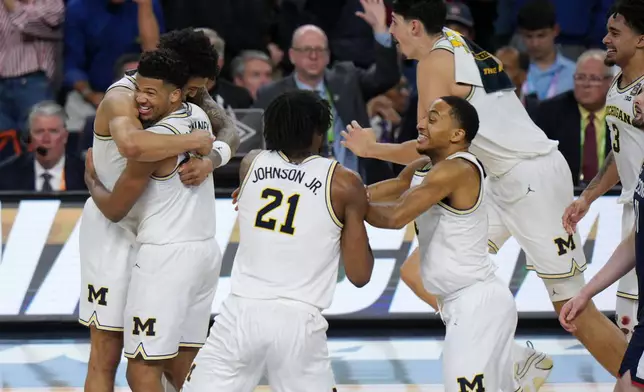 Michigan celebrates after defeating UConn in the NCAA college basketball tournament national championship game at the Final Four, Monday, April 6, 2026, in Indianapolis. (AP Photo/AJ Mast)