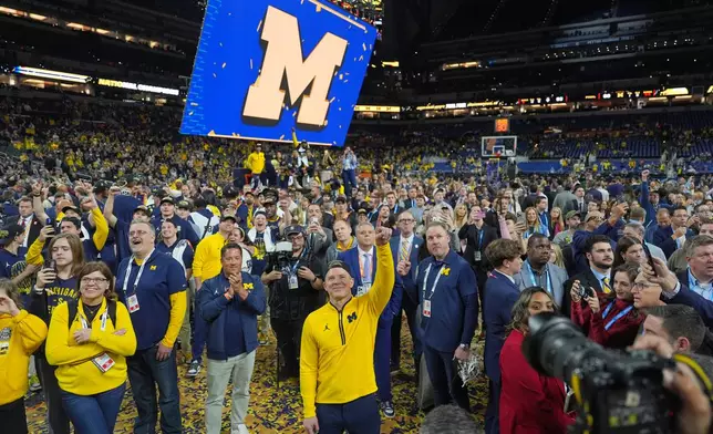 Michigan head coach Dusty May celebrates after defeating UConn in the NCAA college basketball tournament national championship game at the Final Four, Tuesday, April 7, 2026, in Indianapolis. (AP Photo/Michael Conroy)