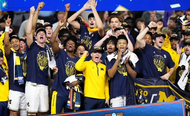 Michigan celebrates after defeating UConn in the NCAA college basketball tournament national championship game at the Final Four, Monday, April 6, 2026, in Indianapolis. (AP Photo/AJ Mast)