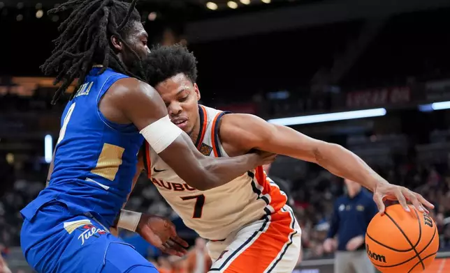 Auburn guard Keyshawn Hall (7) drives on Tulsa guard Ade Popoola during the first half of the NCAA college basketball NIT Championship game, Sunday, April 5, 2026, in Indianapolis. (AP Photo/Abbie Parr)