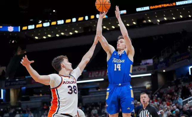 Tulsa guard Miles Barnstable (14) shoots over Auburn forward Filip Jovic (38) during the second half of the NCAA college basketball NIT Championship game, Sunday, April 5, 2026, in Indianapolis. (AP Photo/Abbie Parr)