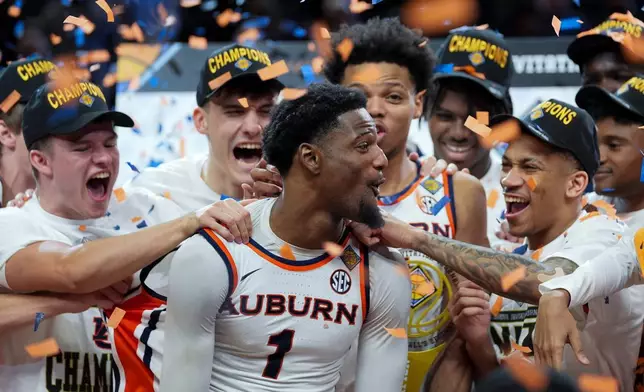 Auburn guard Kevin Overton (1) celebrates with teammates after the NCAA college basketball NIT Championship game against Tulsa, Sunday, April 5, 2026, in Indianapolis. (AP Photo/Abbie Parr)