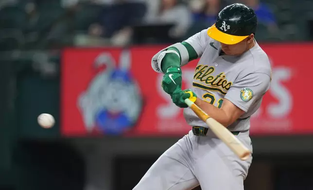Athletics' Tyler Soderstrom swings at a pitch from Texas Rangers starting pitcher Nathan Eovaldi while connecting on a solo home run during the first inning of a baseball game Friday, April 24, 2026, in Arlington, Texas. (AP Photo/Julio Cortez)