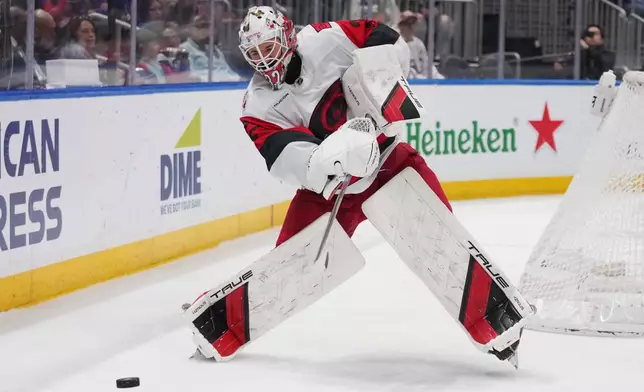 Carolina Hurricanes goaltender Brandon Bussi (32) clears the puck during the second period of an NHL hockey game against the New York Islanders Tuesday, April 14, 2026, in Elmont, N.Y. (AP Photo/Frank Franklin II)