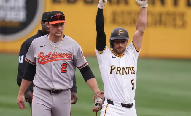 Pittsburgh Pirates' Brandon Lowe (5) celebrates as Baltimore Orioles shortstop Gunnar Henderson (2) holds the tag after hitting a double during the first inning of a baseball game in Pittsburgh, Friday, April 3, 2026. (AP Photo/Gene J. Puskar)