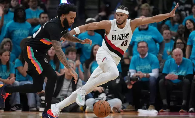 San Antonio Spurs forward Julian Champagnie (30) drives against Portland Trail Blazers forward Toumani Camara (33) during the first half in Game 1 of a first-round NBA playoffs basketball series in San Antonio, Sunday, April 19, 2026. (AP Photo/Eric Gay)