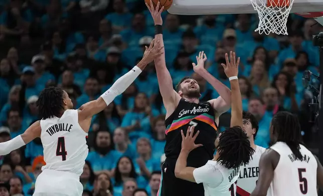 San Antonio Spurs center Luke Kornet (7) scores over Portland Trail Blazers guard Shaedon Sharpe (17) during the first half in Game 1 of a first-round NBA playoffs basketball series in San Antonio, Sunday, April 19, 2026. (AP Photo/Eric Gay)