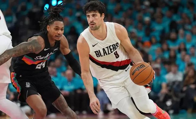 Portland Trail Blazers forward Deni Avdija (8) drives against San Antonio Spurs guard Devin Vassell (24) during the first half in Game 1 of a first-round NBA playoffs basketball series in San Antonio, Sunday, April 19, 2026. (AP Photo/Eric Gay)
