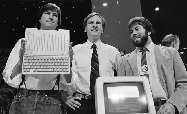 FILE - Steve Jobs, left, chairman of Apple Computers, John Sculley, center, president and CEO, and Steve Wozniak, co-founder of Apple, unveil the new Apple IIc computer in San Francisco, Calif., April 24, 1984. (AP Photo/Sal Veder, File)