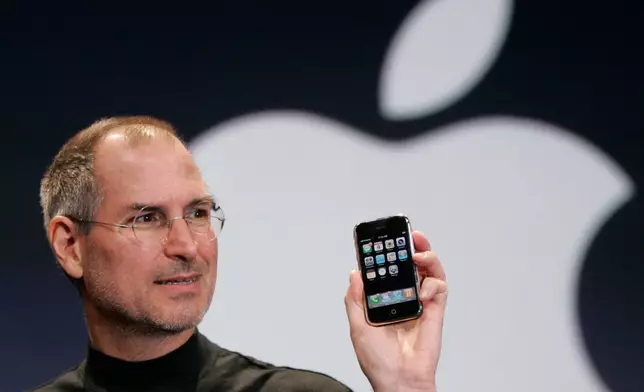 FILE - Apple CEO Steve Jobs holds up an Apple iPhone at the MacWorld Conference, Jan. 9, 2007, in San Francisco. (AP Photo/Paul Sakuma, File)
