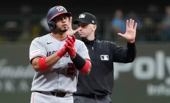 Washington Nationals' Keibert Ruiz, left, claps after hitting an RBI double during the ninth inning of a baseball game against the Milwaukee Brewers, Saturday, April 11, 2026, in Milwaukee. (AP Photo/Aaron Gash)