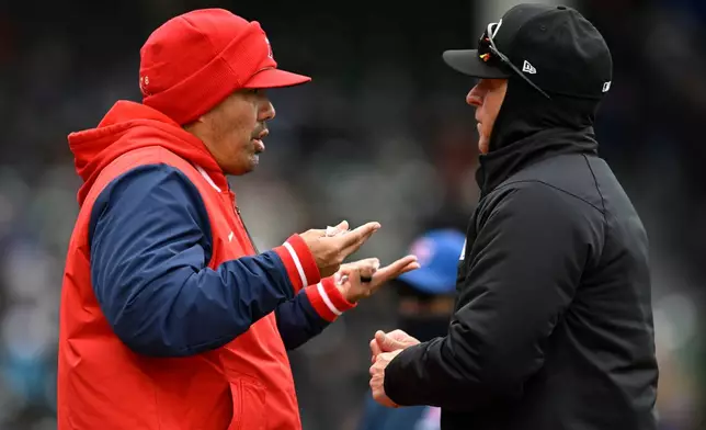 Los Angeles Angels manager Kurt Suzuki, left, attempts to challenge a play with an umpire during the third inning of a baseball game against the Chicago Cubs in Chicago, Wednesday, April 1, 2026. (AP Photo/Paul Beaty)
