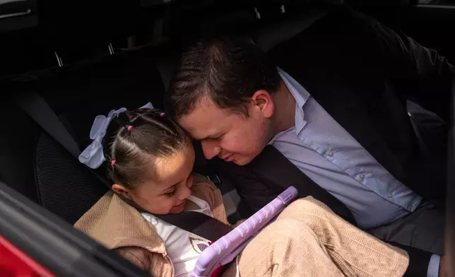 Milenko Faria, whose wife, Dr. Rubeliz Bolivar, is in immigration custody, shares a moment with their daughter, Milena, after his asylum interview at the U.S. Citizenship and Immigration Services facility in Tustin, Calif., Thursday, April 16, 2026. (AP Photo/Jae C. Hong)