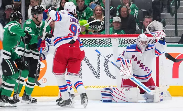 New York Rangers goaltender Igor Shesterkin, right, makes a save against the Dallas Stars during the second period of an NHL hockey game Saturday, April 11, 2026, in Dallas. (AP Photo/Julio Cortez)