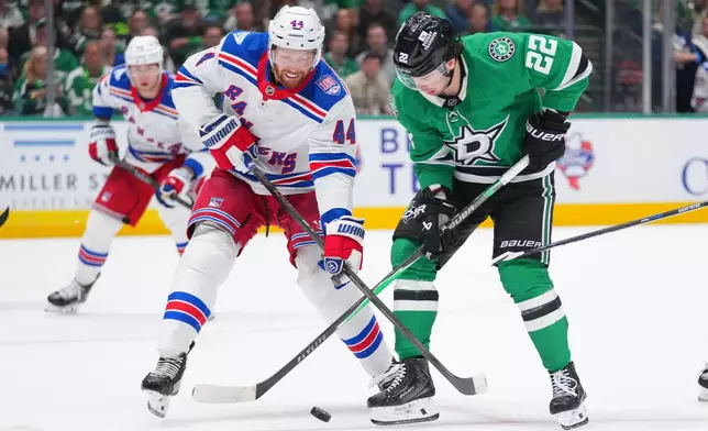 New York Rangers defenseman Vladislav Gavrikov (44) and Dallas Stars center Mavrik Bourque (22) compete for possession of the puck during the first period of an NHL hockey game Saturday, April 11, 2026, in Dallas. (AP Photo/Julio Cortez)