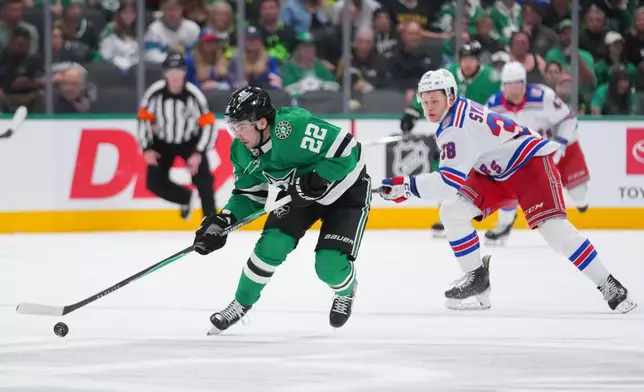 Dallas Stars center Mavrik Bourque (22) breaks away with the puck as New York Rangers left wing Adam Sykora (38) chases him during the first period of an NHL hockey game Saturday, April 11, 2026, in Dallas. (AP Photo/Julio Cortez)