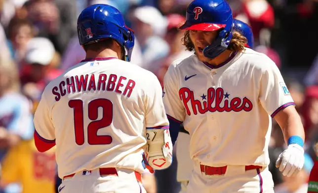 Philadelphia Phillies' Kyle Schwarber (12) celebrates his three-run home run off Arizona Diamondbacks pitcher Brandon Pfaadt with Alec Bohm, right, during the third inning of a baseball game, Saturday, April 11, 2026, in Philadelphia. (AP Photo/Derik Hamilton)
