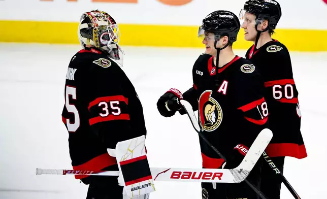 Ottawa Senators goaltender Linus Ullmark (35) celebrates with teammate Tim Stützle (18) after their team's win over the Carolina Hurricanes in an NHL hockey game in Ottawa, Ontario, on Sunday, April 5, 2026. (Spencer Colby/The Canadian Press via AP)