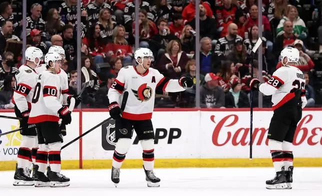 Ottawa Senators center Shane Pinto (12) is congratulated by Claude Giroux (28) after scoring during the second period of an NHL hockey game against the New Jersey Devils Sunday, April 12, 2026, in Newark, N.J. (AP Photo/Adam Hunger)