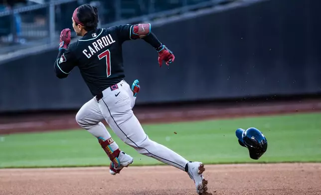 Arizona Diamondbacks' Corbin Carroll (7) loses his helmet as he runs to third base on a triple during the seventh inning of a baseball game against the New York Mets, Wednesday, April 8, 2026, in New York. (AP Photo/Angelina Katsanis)
