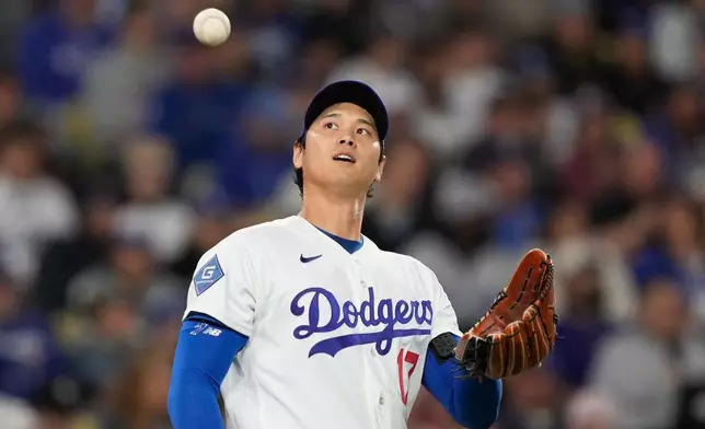Los Angeles Dodgers starting pitcher Shohei Ohtani takes a new ball after Miami Marlins' Christopher Morel scored on a single by Kyle Stowers during the fifth inning of a baseball game Tuesday, April 28, 2026, in Los Angeles. (AP Photo/Mark J. Terrill)