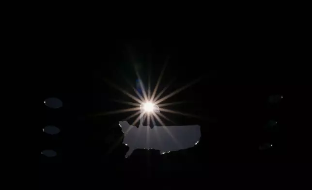 The sun shines through a cut-out Masters logo on the third hole during the second round of the Masters golf tournament at the Augusta National Golf Club, Friday, April 10, 2026, in Augusta, Ga. (AP Photo/Matt Slocum)