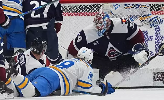 Colorado Avalanche goaltender MacKenzie Blackwood, right, stops a shot by St. Louis Blues center Robert Thomas, front right, as Colorado center Jack Drury defends in the first period of an NHL hockey game Sunday, April 5, 2026, in Denver. (AP Photo/David Zalubowski)