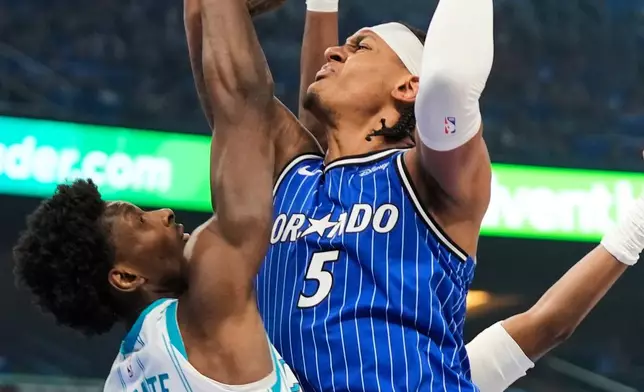 Orlando Magic forward Paolo Banchero (5) shoots over Charlotte Hornets forward Moussa Diabate, left, during the first half of an NBA play-in tournament basketball game, Friday, April 17, 2026, in Orlando, Fla. (AP Photo/John Raoux)