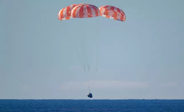 In this photo provided by NASA, the Orion spacecraft with Artemis II crewmembers aboard approaches the surface of the Pacific Ocean for splashdown off the coast of California, Friday, April 10, 2026. (Bill Ingalls/NASA via AP)