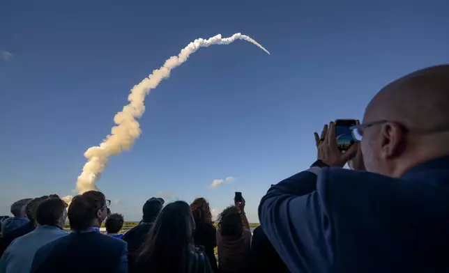 In this photo provided by NASA, guests watch the launch of the Space Launch System (SLS) rocket and Orion spacecraft for the Artemis II mission to the moon at NASA's Kennedy Space Center in Florida on Wednesday, April 1, 2026. (Bill Ingalls/NASA via AP)