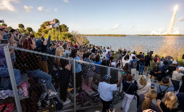 In this photo provided by NASA, guests at the Banana Creek viewing site watch the launch of the Space Launch System (SLS) rocket and Orion spacecraft for the Artemis II mission at NASA's Kennedy Space Center in Florida on Wednesday, April 1, 2026. (Keegan Barber NASA via AP)
