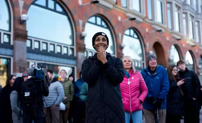 People react on Elgin Street as the Artemis II moon rocket lifts off, on a livestream displayed on the Kipnes Lantern of the National Arts Centre in Ottawa, Ontario, Wednesday, April 1, 2026. (Justin Tang/The Canadian Press via AP)