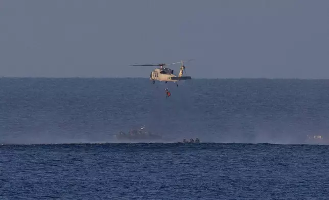 In this photo provided by NASA, a helicopter lifts up one of the astronauts from Artemis II after splashdown in the Pacific Ocean off the coast of California, Friday, April 10, 2026. (Joel Kowsky/NASA via AP)