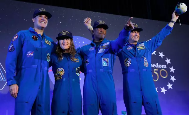 The Artemis II crew, from left, Jeremy Hansen, Christina Koch, Victor Glover and Reid Wiseman come to the center stage at the end of a crew return event Saturday, April 11, 2026, at Ellington Field in Houston. (AP Photo/Michael Wyke)